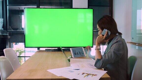女商人与电视上的视频会议显示器绿色屏幕色度键