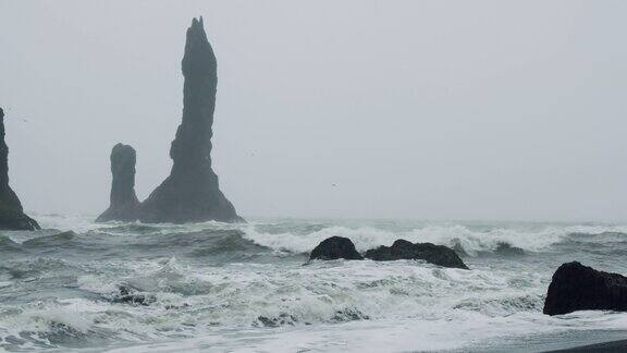 冰岛维克的Reynisfjara黑沙滩上的悬崖和海浪