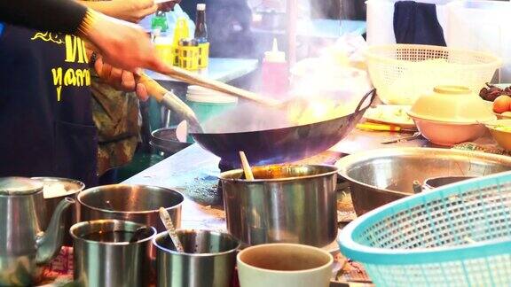 在泰国曼谷唐人街做街边小吃在平底锅里炒面条火和火焰下它