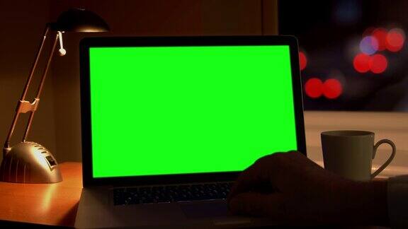 用笔记本电脑工作到很晚通过窗口回家色度键绿色屏幕