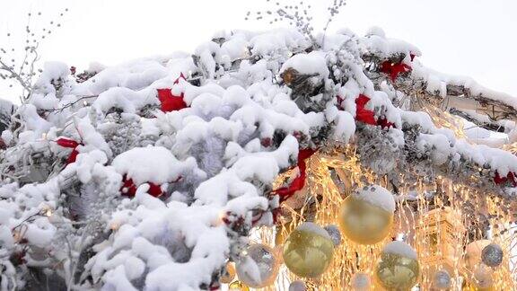 莫斯科街道上房顶上覆盖着雪的圣诞装饰品和在风中摇曳的发光的花环