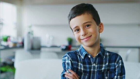 一个有着棕色眼睛的小男孩的肖像在厨房的背景上看着摄像机