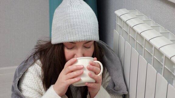 女人喝热饮试图用电池取暖