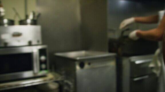 手持拍摄的两个年轻的西班牙男性厨师在一个商业厨房在墨西哥餐厅电镀熟蔬菜培根卷虾和米饭