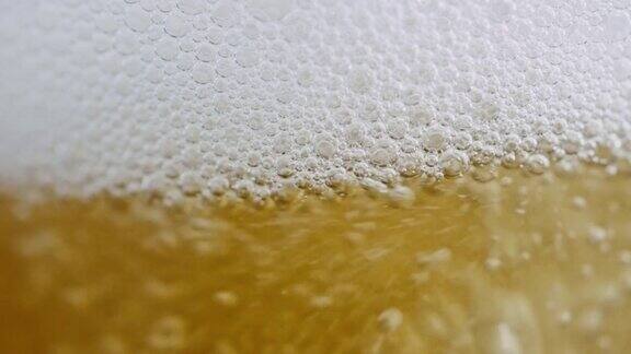 慢镜头的特写镜头倒啤酒与泡沫和泡沫到一个杯子