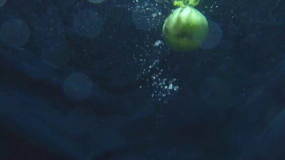 成熟的青苹果果实落入水中健康食品和素食
