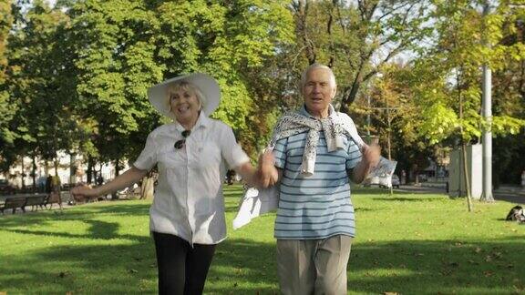 老两口快乐的游客在镇中心公园里蹦蹦跳跳