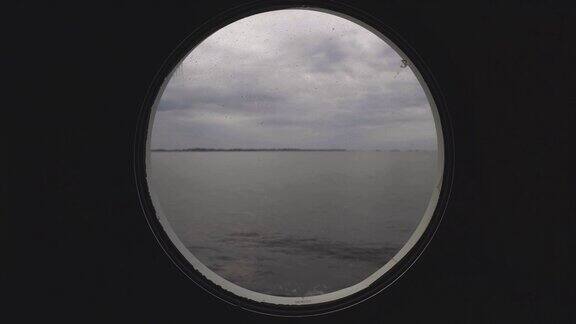 从平静海面上一艘船的舷窗里