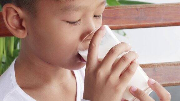 亚洲男孩早餐喝一杯新鲜牛奶