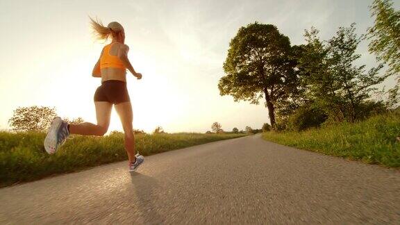 SLOMOTS女跑步者跑到农村的日落
