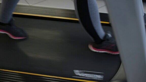 在健身房跑步机上锻炼的女人
