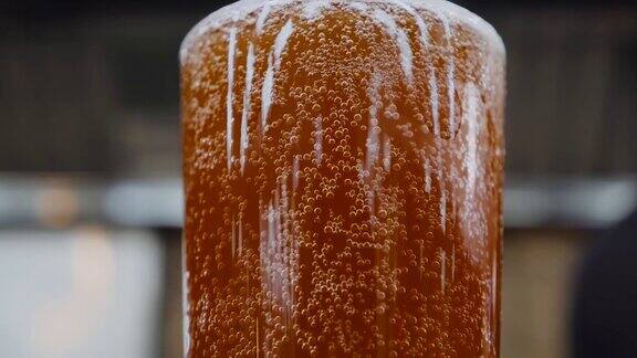 彩色背景上的一杯冰凉的黑啤酒气泡慢慢地上升精酿啤酒特写镜头