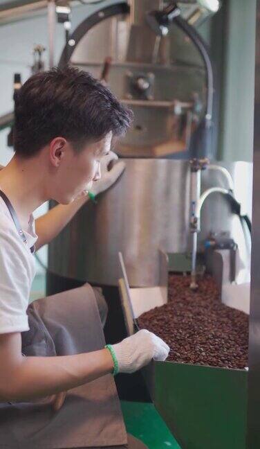 亚洲的中国工匠在他的工厂里检查烘培咖啡豆从冷却过程中旋转出来后的去石过程