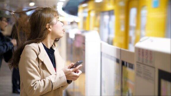 一个女人在火车站用智能手机
