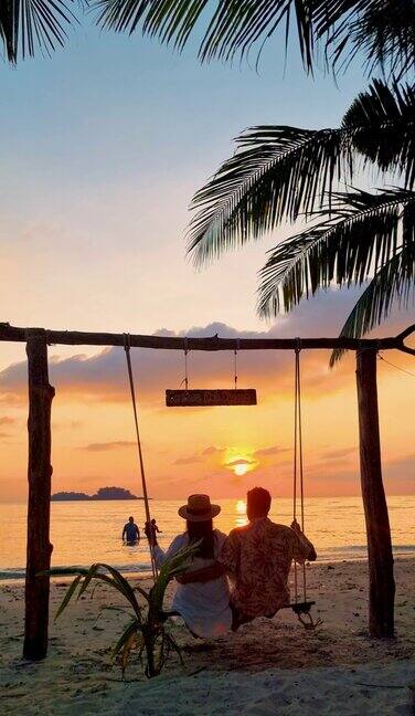 一对男女在泰国高昌岛的秋千上看日落