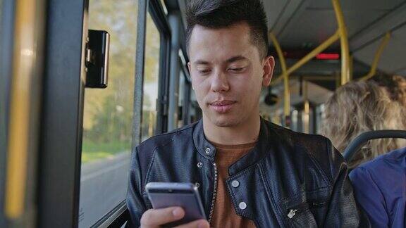 一个年轻人在公交车上用智能手机
