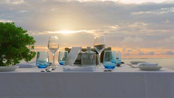 餐桌上有海边的美食小吃酒席上有户外的新鲜空气在白色的桌布上装饰着黄色的花盘花瓶上装饰着装饰品各种玻璃杯