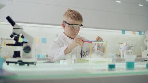 男孩在实验室里做科学实验用肥皂泡液研究表面张力