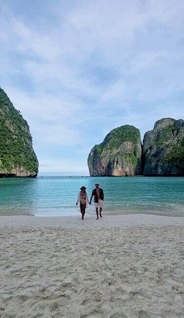 一对男女走在海滩上泰国披披岛玛雅海滩的清晨