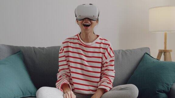年轻女性佩戴VR头显在家中客厅体验模拟数字世界