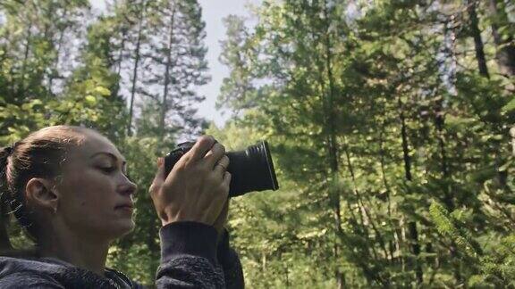 游客在森林中拍摄风景一名白人女性拍摄了漂亮的魔术女孩用无反光镜单反相机拍摄视频