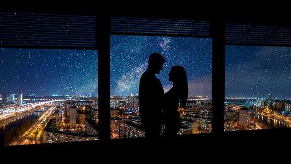 一男一女站在窗前背景是夜晚的城市