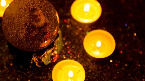 圣诞纪念品在点燃的蜡烛和闪光的背景