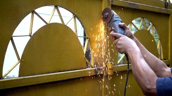 金属角磨床切割时产生火花在金属车间工作的铁匠工人使用工业磨床慢动作