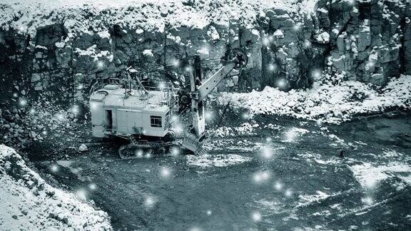 巨大的黄色挖掘机在花岗岩采石场冬天带着一场大雪