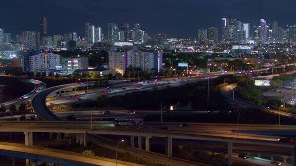 夜间鸟瞰图迈阿密设计区和遥远的迈阿密市中心在大高架路口在北迈阿密佛罗里达无人机拍摄的b-roll镜头和平移摄像机的运动