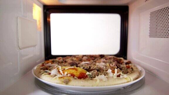 微波炉里解冻冷冻海鲜披萨的人把晚餐放进烤箱