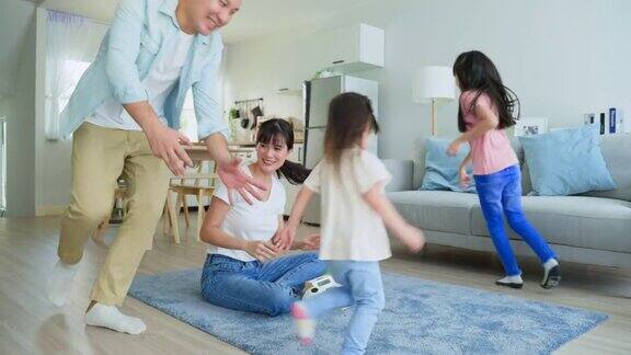 亚洲家庭一起在家里的客厅度假漂亮快乐的父母爸爸带着年幼的小女儿在家里围着妈妈跑活动的关系