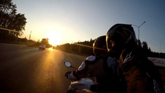 日落时分两名男子骑着摩托车高速行驶在乡村公路上朋友们骑着自行车向太阳高速前进自拍观点关闭
