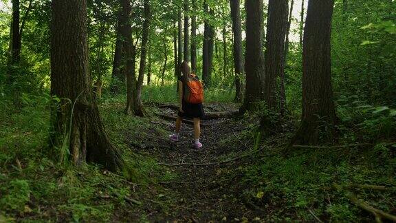 背着背包的人女孩穿过森林