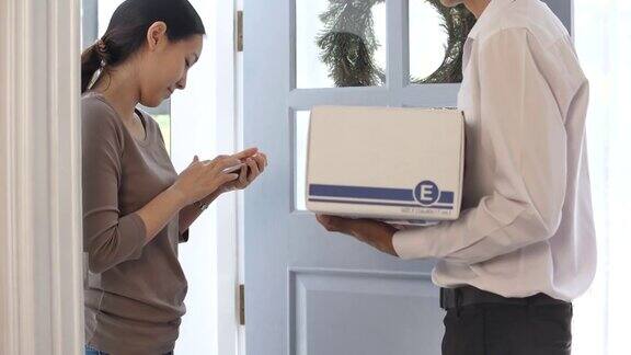收件人在家中签收电子后快递员将包裹交给收件人