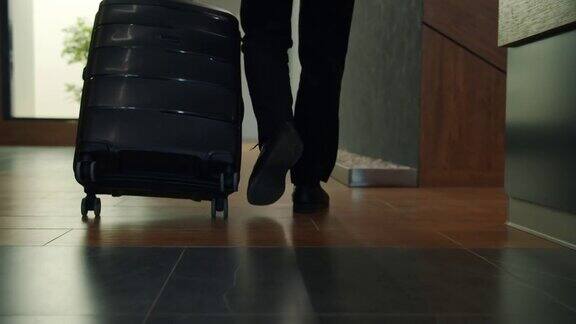 慢动作低镜头男性的腿走在酒店大厅移动手提箱去房间