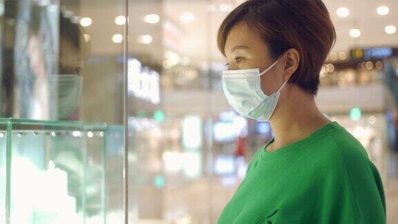一个女人戴着一次性医用口罩在商场购物