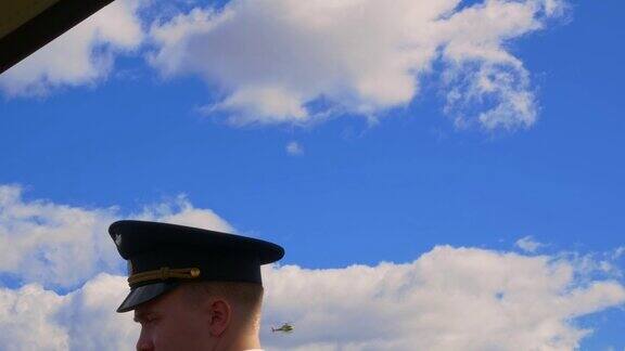 机场、飞行员、飞机穿着制服的自信男飞行员画像在直升机飞行的天空背景下戴着帽子的上尉机场的直升机机长