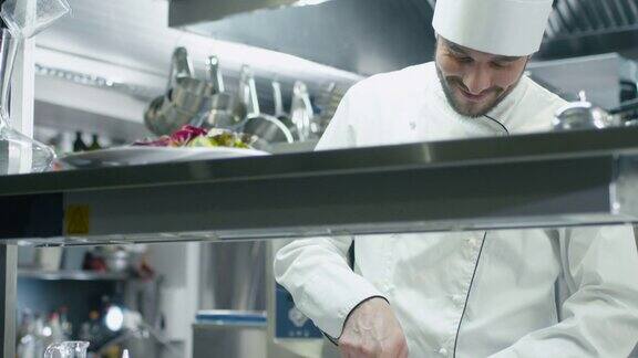 饭店或酒店商业厨房的专业厨师正在切绿色蔬菜