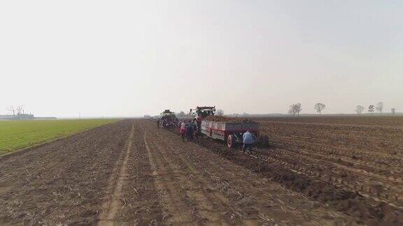 人们走在拖拉机后面做农活摄像头提升