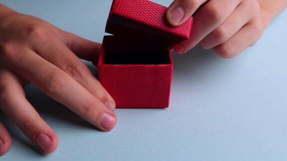 用手打开和关上一个红色礼品盒的盖子