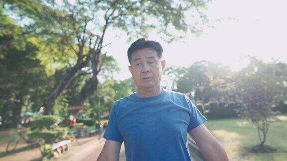 亚洲中年男子在公园做热身运动摆动和旋转手臂肩部退休生活健身保健阳光明媚的日子锻炼活力健康老年疾病预防