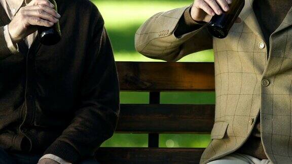老朋友们坐在公园的长椅上畅饮着啤酒