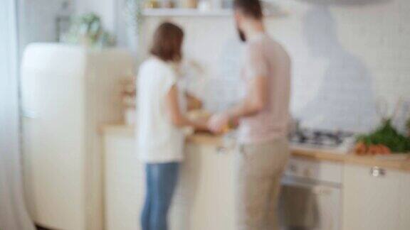 年轻夫妇一起做饭在厨房里聊天准备晚饭在家