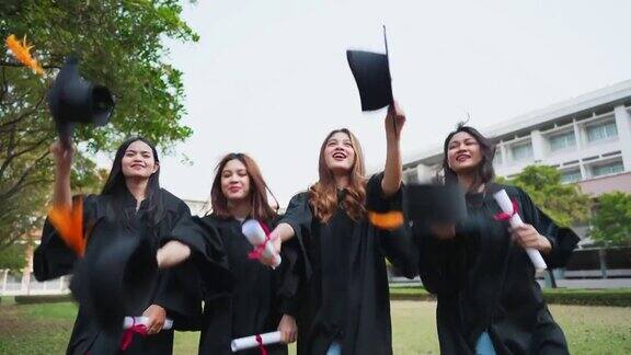 一群亚洲学生身穿学位袍头戴毕业帽手持学位证书