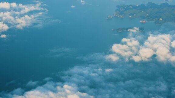 在阳光明媚的早晨从飞机窗口俯瞰蓝天和云朵海面在平流层之上