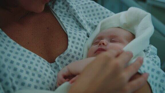 母亲在医院里羡慕熟睡的新生婴儿