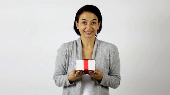 女人收到的礼物装在白色的礼盒里上面系着红丝带她对送礼者表示赞赏