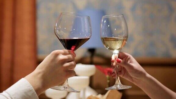年轻夫妇在餐厅用酒杯和香槟敬酒两个人在聚会上用香槟和葡萄酒敬酒在生日聚会或公司招聘时欢呼庆祝