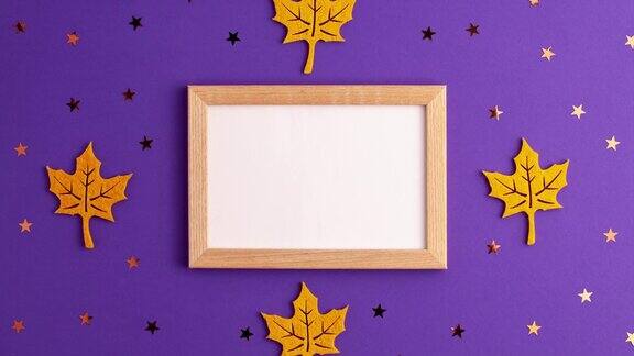 定格动画的黄色毡秋天树叶星星形状和木制画框的紫色背景与复制空间万圣节的恐怖节日和秋天